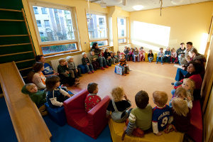 Kinder sitzen im Kreis um das Geburtstagskind