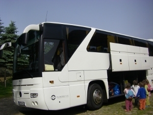 Großer Bus mit kleinen Kindern vor dem Gepäckfach